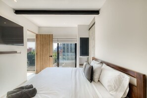 A modern hotel room with a large bed, a TV mounted on the wall, and a balcony with a city view. - Myla - Casa Calderon - Roma Norte (HF) (Mexico City)