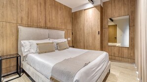 Ein modernes Schlafzimmer mit einem großen Bett, Holzwandverkleidung, einem Nachttisch und einem Spiegel.