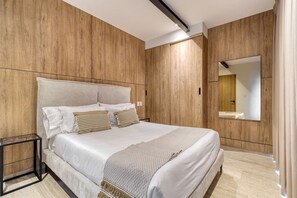 Un dormitorio moderno con una cama grande, paneles de madera, una mesita de noche y un espejo.