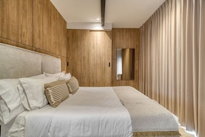 Ein modernes Schlafzimmer mit einem großen Bett, Holzwandverkleidung, einem Spiegel und Blick ins Freie.