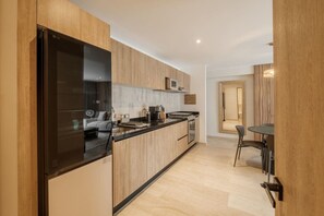 A modern kitchen with a built-in refrigerator, microwave, and stove. - Casa Monroy - 1BR en Roma Norte - LowF (Mexico City)