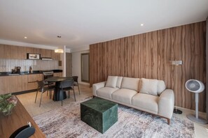 A modern living room with a sofa, a dining table, and a kitchen area. - Casa Monroy - 1BR en Roma Norte - LowF (Mexico City)
