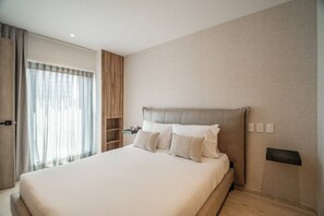 A modern hotel room with a large bed, a built-in wardrobe, and a view of the outdoors. - Casa Monroy - 1BR en Roma Norte - LowF (Mexico City)