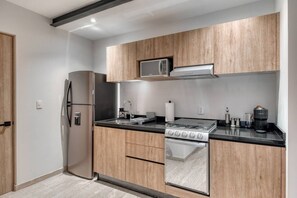 Eine moderne Küche mit einem Edelstahl-Kühlschrank, einer Mikrowelle, einem Gasherd und einem eingebauten Backofen.