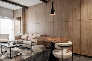 Ein modernes Wohnzimmer mit einer Couch, einem runden Tisch und einer Pendelleuchte.