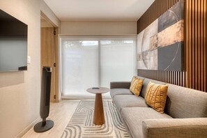 A modern living room with a sofa, a coffee table, a TV, and a large window. - Myla - 01C Roma Norte - LowF (Mexico City)