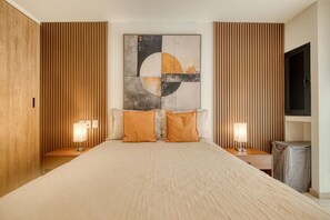 A hotel room with a large bed, wooden paneling on the walls, a large abstract painting, two bedside lamps, and a television on the wall. - Myla - 01C Roma Norte - LowF (Mexico City)