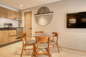 A modern kitchen with wooden cabinets, a gas stove, and a coffee machine. - Myla - 01C Roma Norte - LowF (Mexico City)