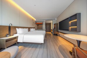 A modern hotel room with a large bed, bedside tables, a TV, and a desk. - UrCove by Hyatt Nanjing South Railway Station BaiJia Lake (Nanjing)