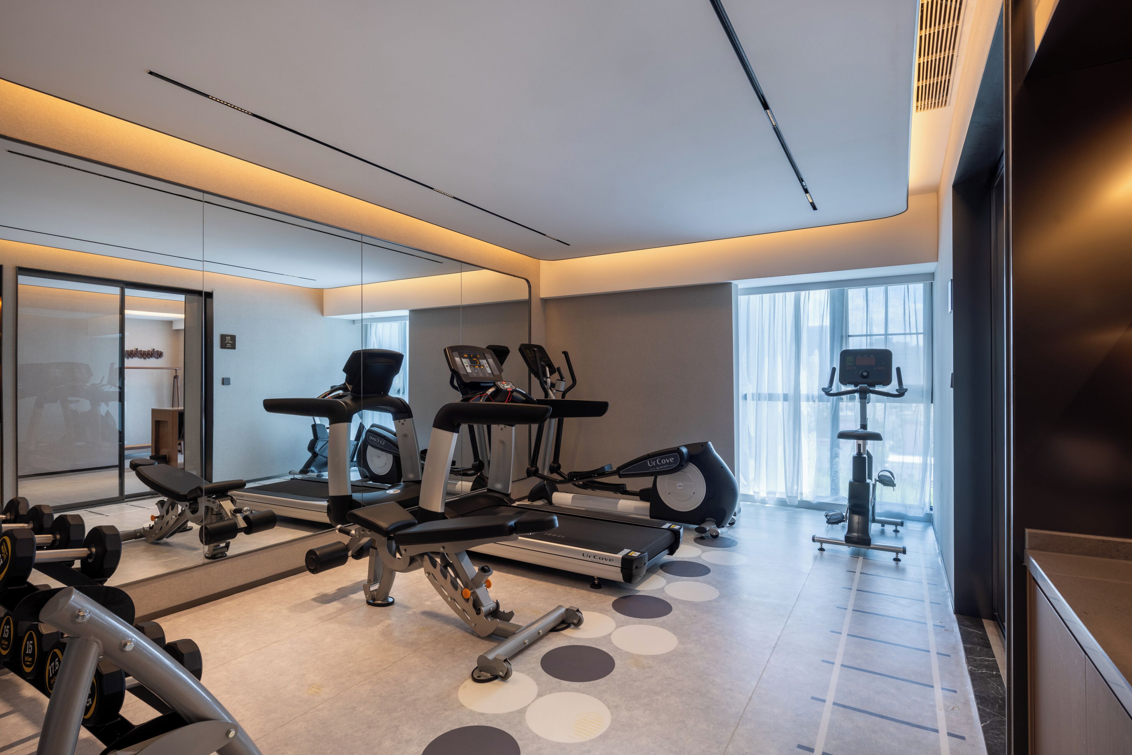 A modern gym with various exercise equipment, including treadmills and weight machines.