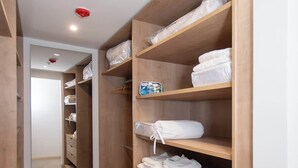 A walk-in closet with wooden shelving, drawers, and a mirrored closet door. - Corporate Stays Alban 1 (Asunción)