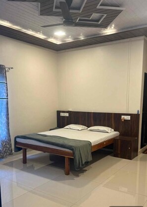Un dormitorio con cama, ventilador de techo e iluminación.