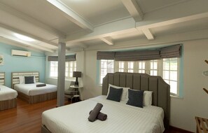 A hotel room with a large bed, two smaller beds, a desk, and a chair. - MaMa Beach Pool Villa Pattaya (Muang Pattaya)