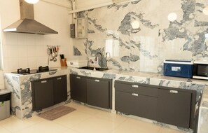 A kitchen with a marble backsplash, a stainless steel range hood, and a built-in dishwasher. - MaMa Beach Pool Villa Pattaya (Muang Pattaya)