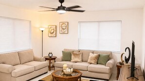 A living room with a sofa, coffee table, and TV stand. - Apartment in Hollywood Beach, a 10-minute drive from the beach (Hollywood)