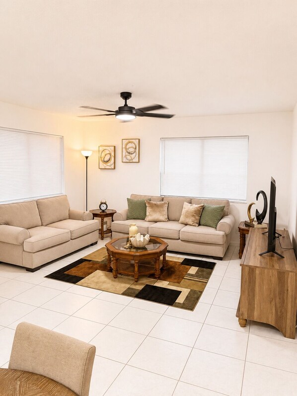 A living room with a sofa, coffee table, and TV stand.