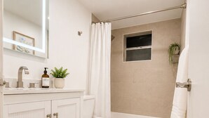 A modern bathroom with a toilet, sink, and bathtub.