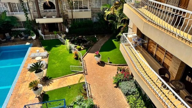 A multi-story hotel with a swimming pool, outdoor seating, and a well-maintained garden. - Deluxe Studio Apartment at Eldon Hotel Apartments (Nairobi)