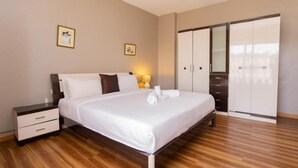 A bedroom with a bed, nightstands, a wardrobe, and two framed pictures on the wall. - Deluxe Studio Apartment at Eldon Hotel Apartments (Nairobi)