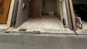 Ein zweistöckiges Gebäude mit Garage, einer Holztür und einem Fahrrad davor geparkt.