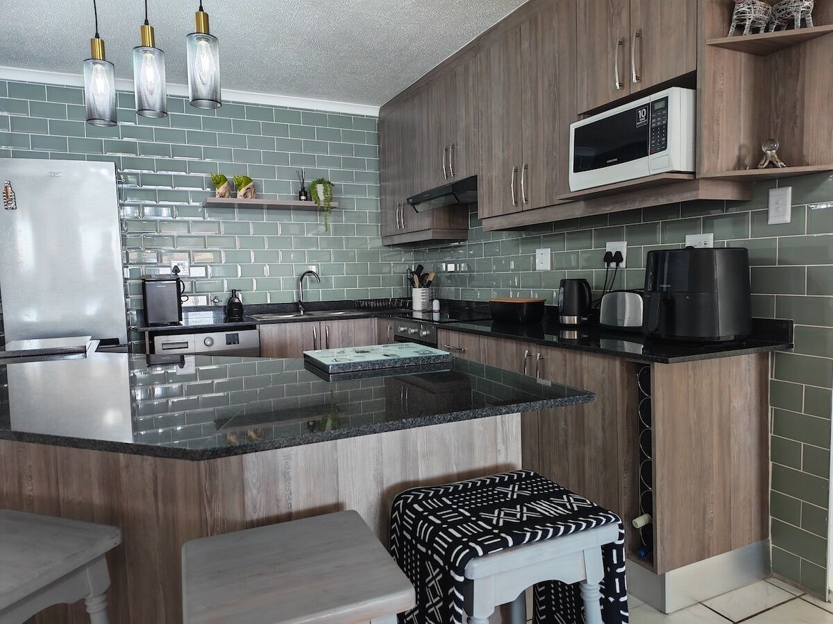 A modern kitchen with a central island, wooden cabinets, a microwave, and a coffee maker.