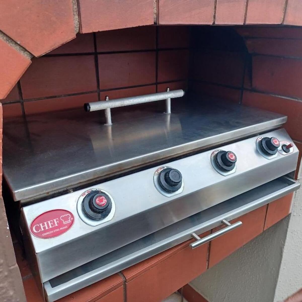 A stainless steel Chef brand gas grill with three burners and a control panel.