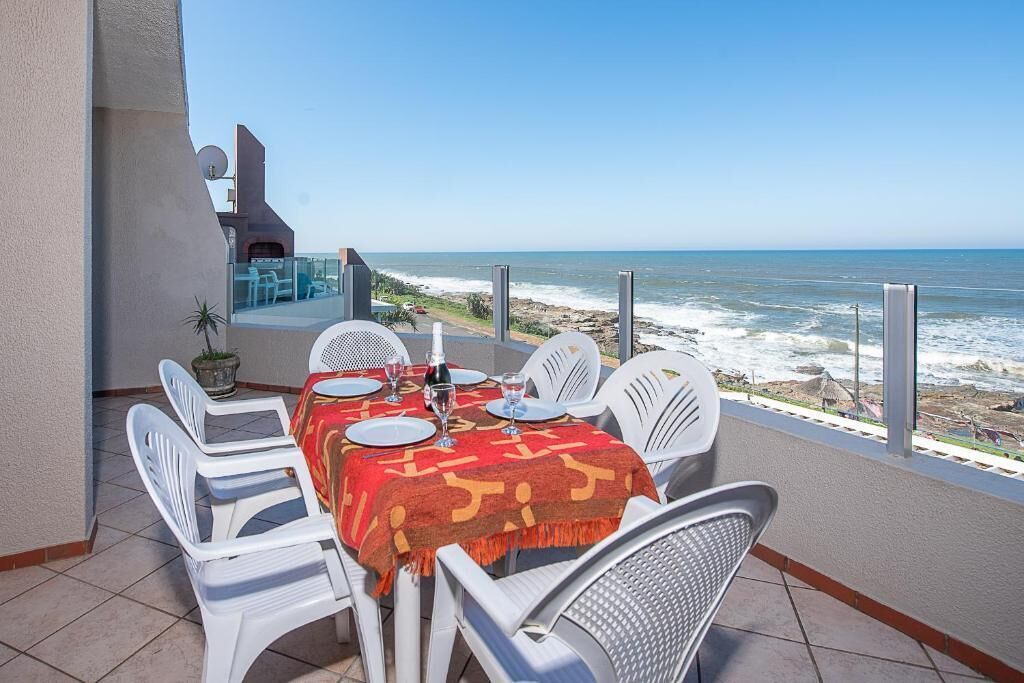 A table set for dining with a view of the ocean.