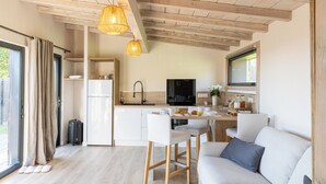 A modern kitchen with a dining area, a sofa, and a TV. - Wellness retreat with a hot tub and fitness center overlooking the lake (Vaivre-et-Montoille)