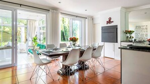 Una cocina moderna con comedor, ventanas amplias y vistas al exterior.