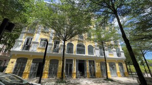 Un edificio amarillo con varias ventanas y una entrada central.