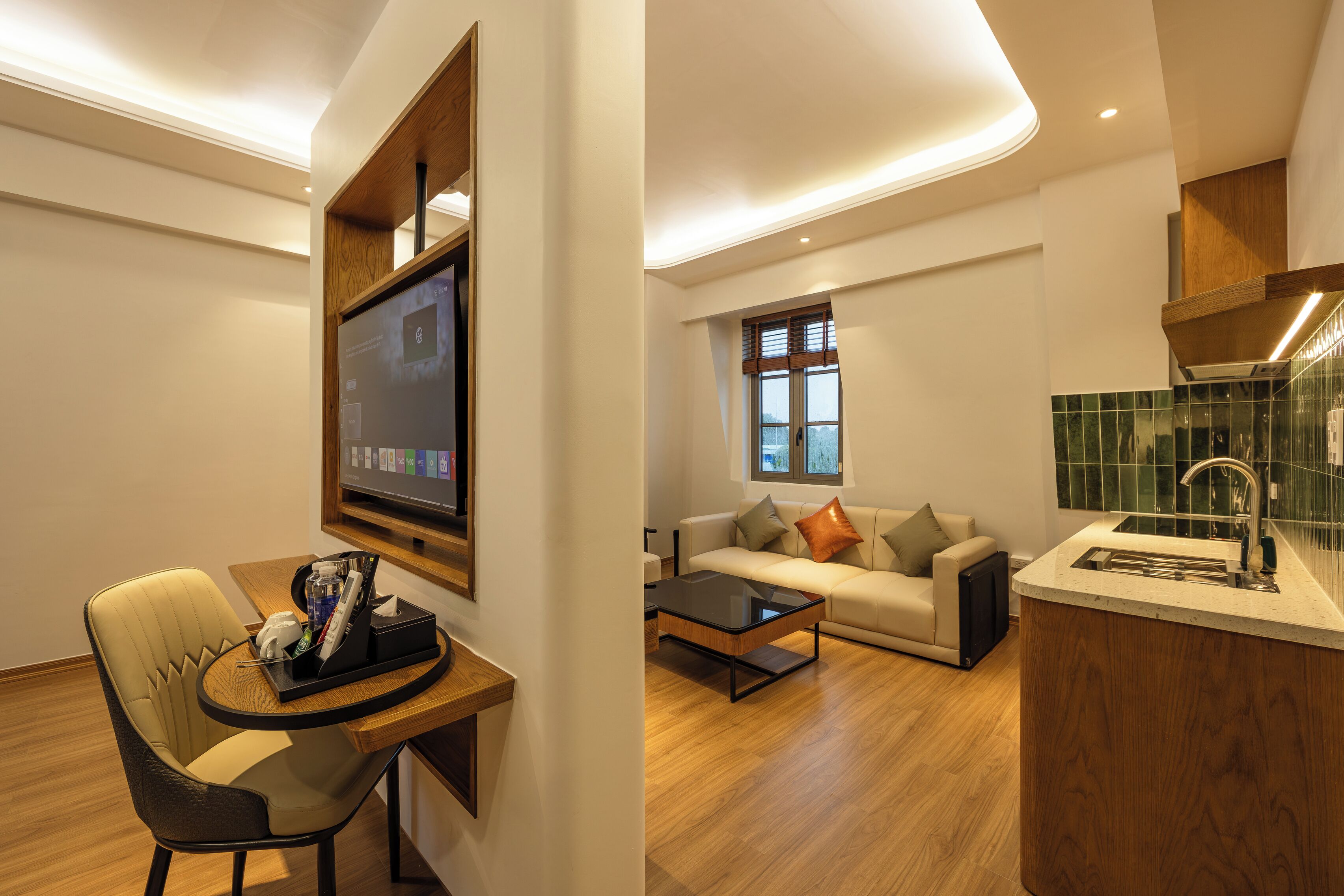Una sala de estar moderna con un sofá, una mesa de centro y un televisor montado en la pared.
