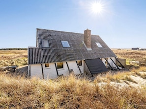 A house with a sloped roof, multiple windows, and a chimney. - 10 Person Holiday Home in Harboore (Harboore)