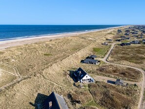 Vue aérienne d’une zone côtière avec des maisons et une plage.