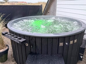 A hot tub with a wooden exterior, a control panel, and a small step leading into it. - 10 Person Holiday Home in Harboore (Harboore)