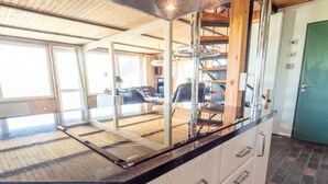 A kitchen with a black countertop, white cabinets, and a stainless steel range hood. - 10 Person Holiday Home in Harboore (Harboore)