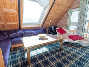 A cozy room with a wooden ceiling, a sofa, a table, and a window. - 10 Person Holiday Home in Harboore (Harboore)