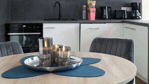 Eine moderne Küche mit Esstisch, Stühlen und einer Kaffeemaschine.