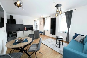 Een modern appartement met een eethoek, keuken en woonkamer.