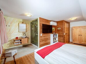 Makuuhuoneessa on sänky, puinen vaatekaappi, seinään upotettu televisio, kylpyhuone, jossa on pesuallas ja peili, sekä suihku.