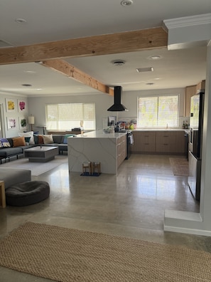 A spacious kitchen with a central island, wooden beams, and a modern design. - Modern Desert Retreat. Pool & Spa . 3 King Suites. Quiet Upper Cove Location (Cathedral City)