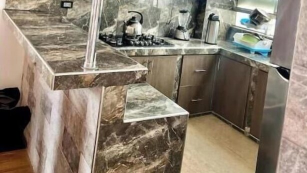 Una cucina moderna con piani in marmo, elettrodomestici in acciaio inossidabile e mobili in legno.
