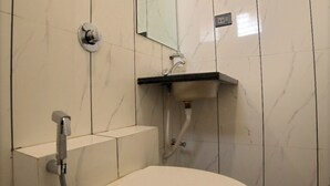 Un baño con inodoro, espejo y lavamanos.