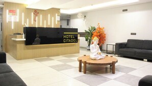 Un mostrador de recepción de hotel con una estatua de Buda en el vestíbulo.