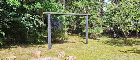 An outdoor wooden structure with a circular seating area surrounded by tree stumps.