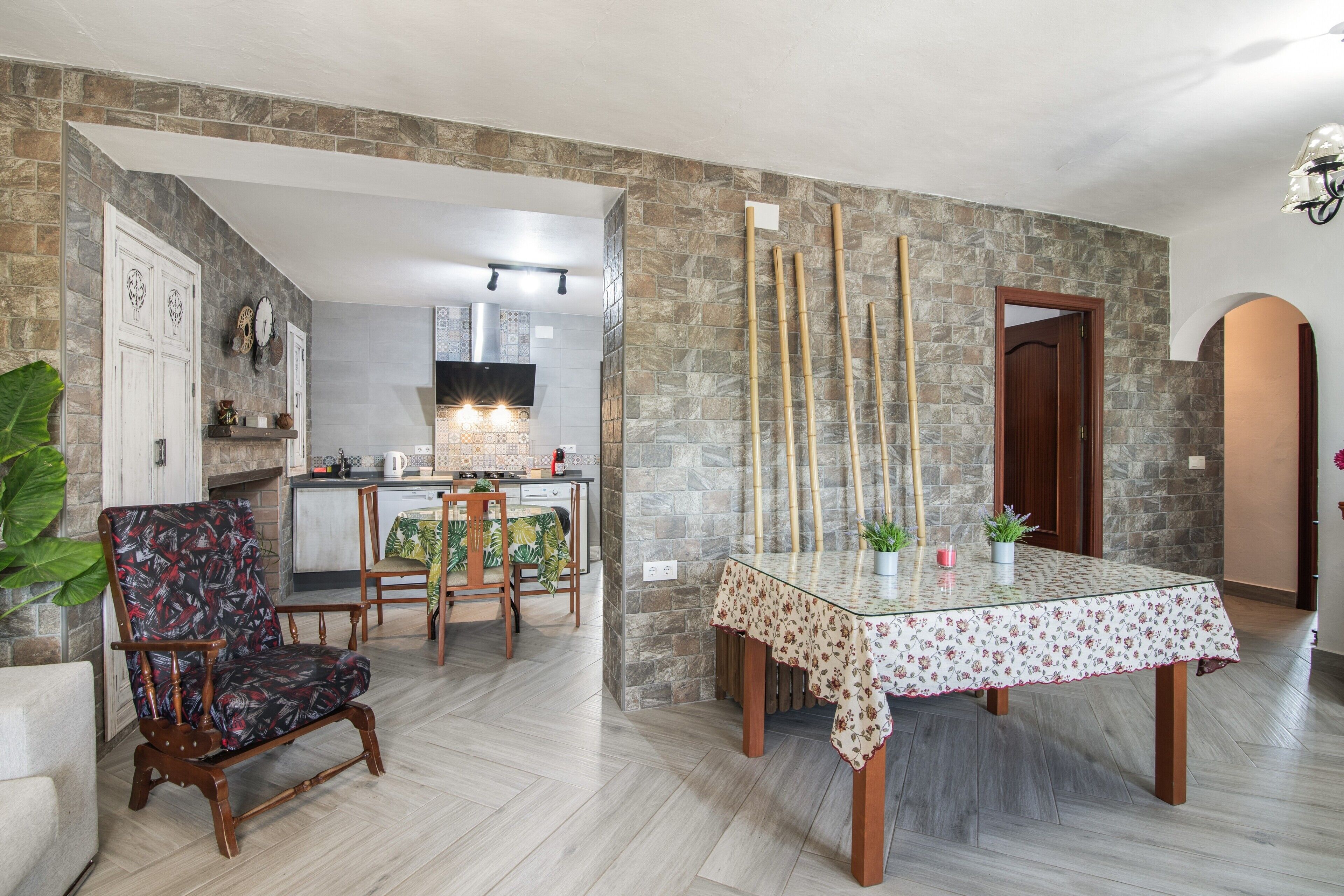 Un comedor con una mesa, sillas y una cocina al fondo.