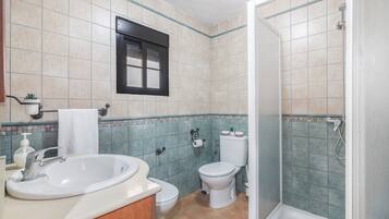 Un baño con lavamanos, inodoro y ducha.