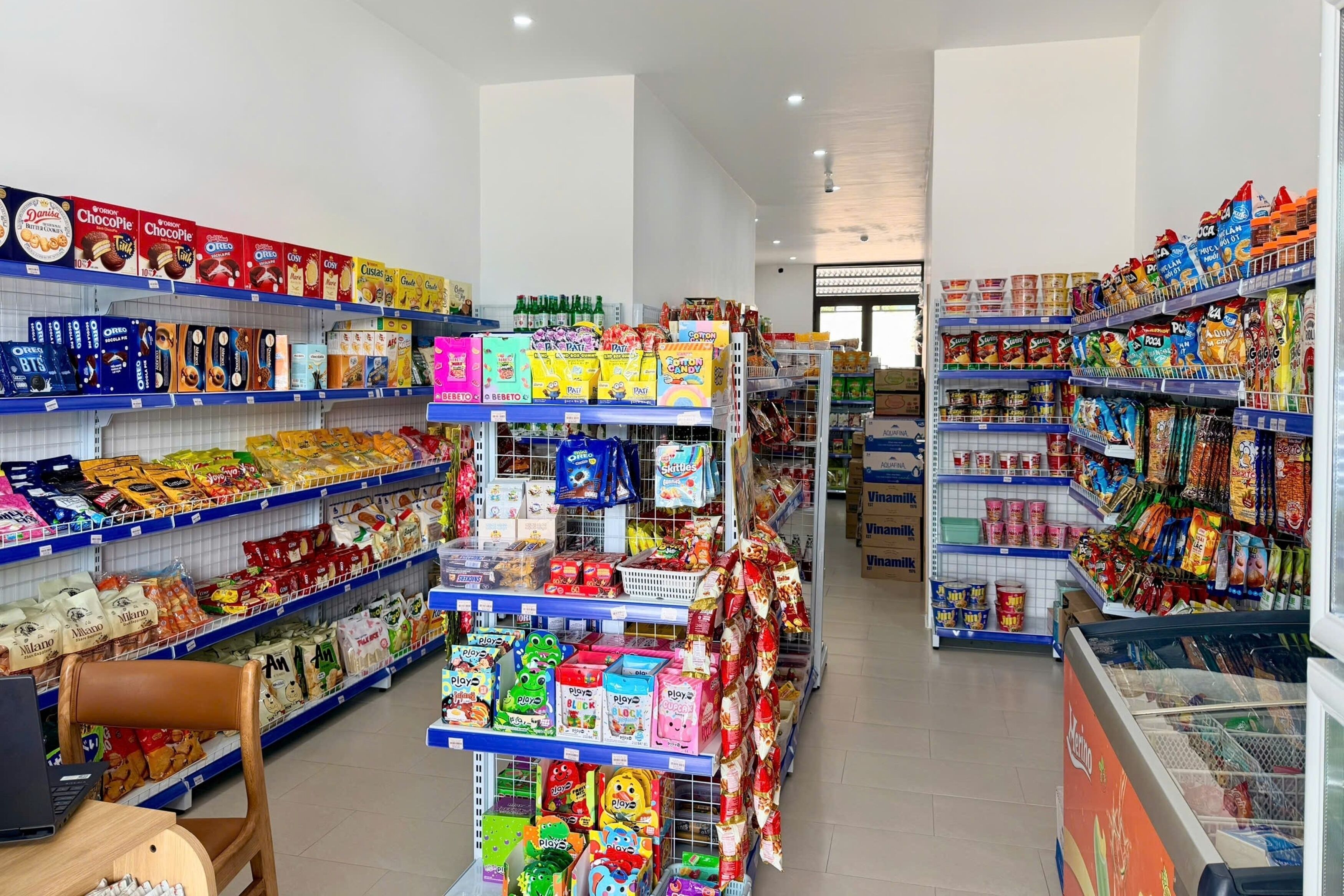 Un pasillo de un supermercado con estantes llenos de botanas, cereales y otros alimentos.