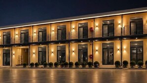 Un hotel con fachada moderna, varios balcones y ventanas distribuidas uniformemente.