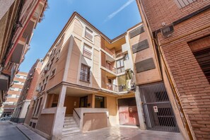 A multi-story residential building with balconies, a gated entrance, and a clear sky. - Apartment 'Las Flores 1' with Wi-Fi and Air Conditioning (Murcia)