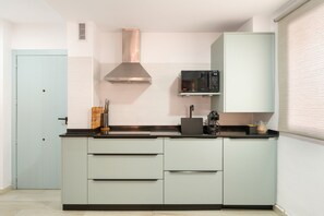Cozinha moderna com micro-ondas, fogão e exaustor.